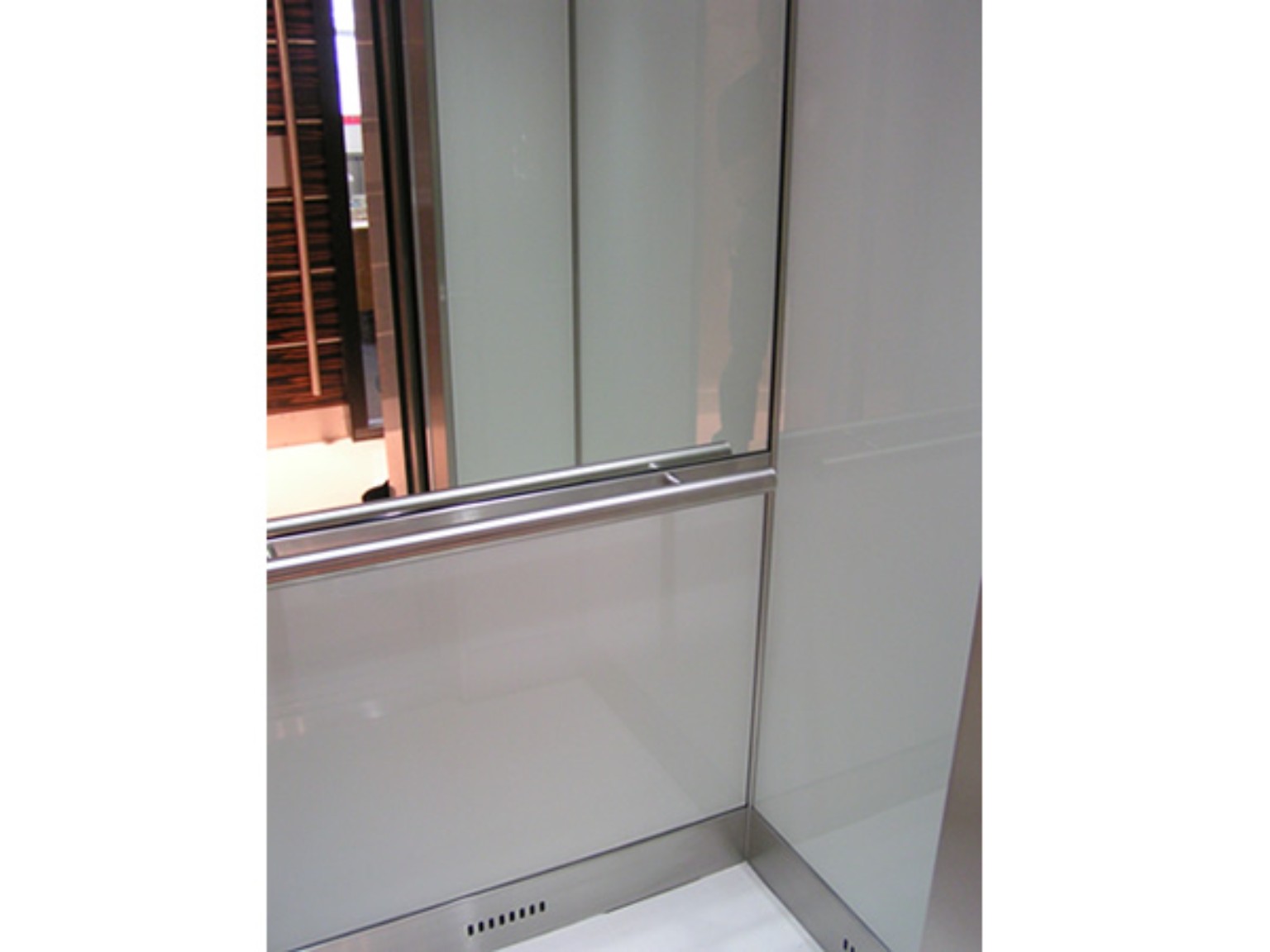 Light-coloured lift wall panels and handrail